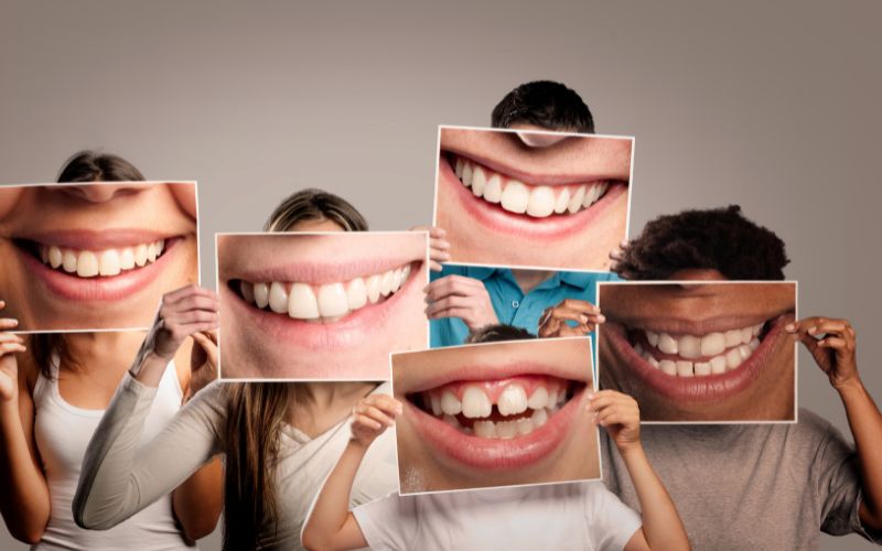 A group of people holding up pictures of their teeth while sharing fun dental facts.