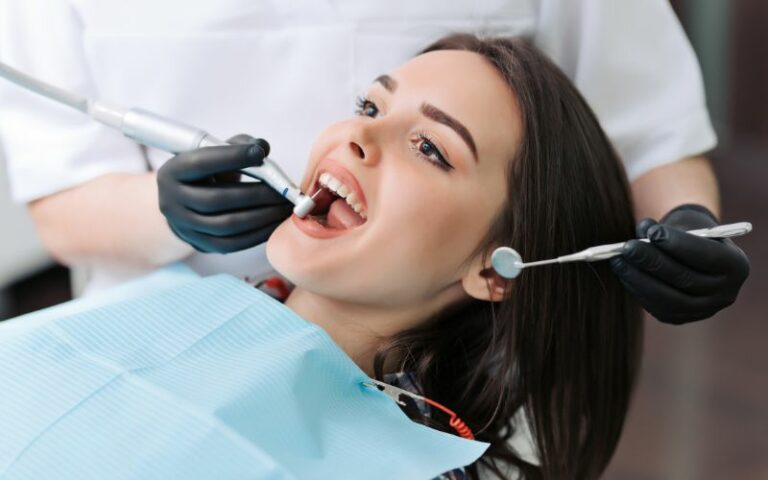 A woman is getting her dental hygiene checked by a dentist.