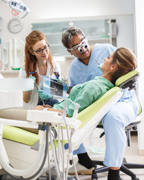 Hamilton dentist and dental hygienist explaining teeth cleaning procedure to patient