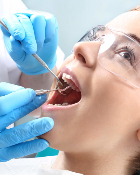 Hamilton dentist cleaning young woman's teeth for root canal therapy