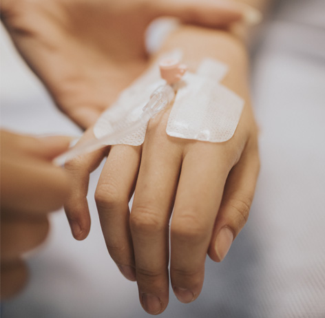 Dentist administering IV solution to sedate anxious patient in sedation dentistry