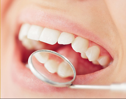 Dentist using dental mirror to examine back of patient's teeth in dentist emergency hamilton