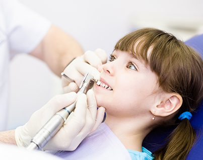 Dental hygienist polishing brave young girl's teeth at hamilton teeth cleaning