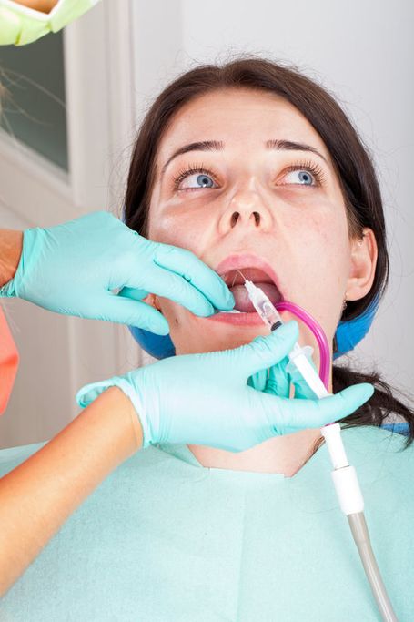 Emergency dentist helping panicked patient through painless procedure at emergency dental in hamilton