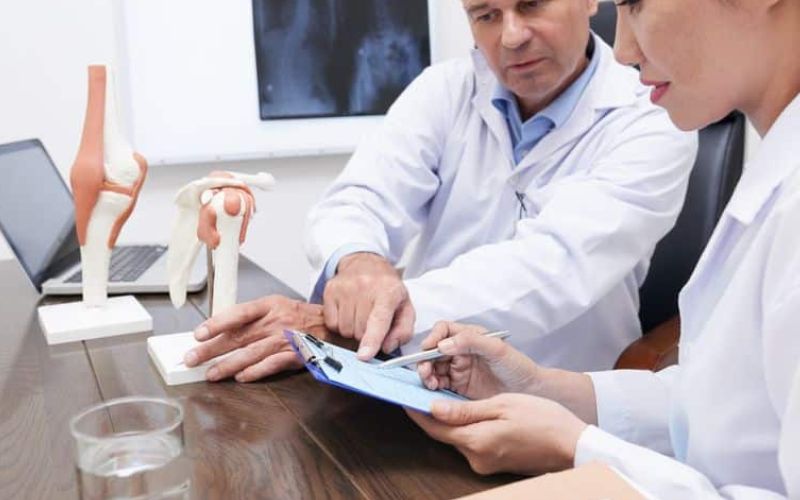 Experienced dentist reviewing medical history form with colleague