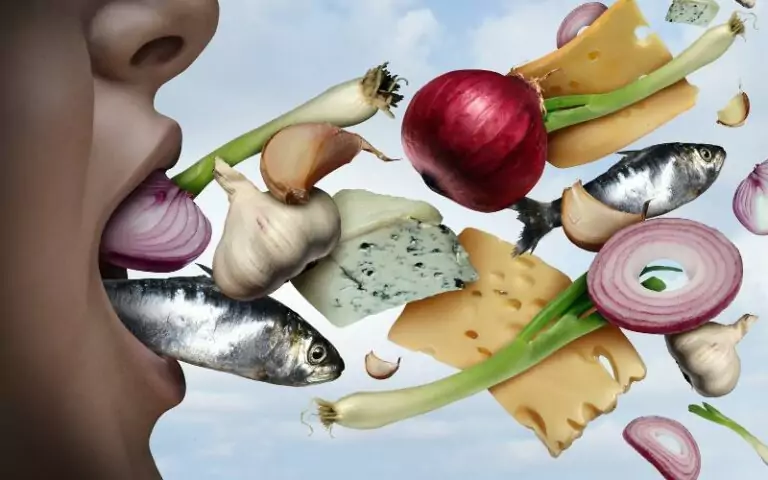 A woman combatting bad breath with food.