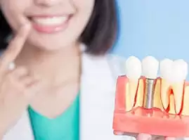 dentist pointing her teeth for dental implant hamilton