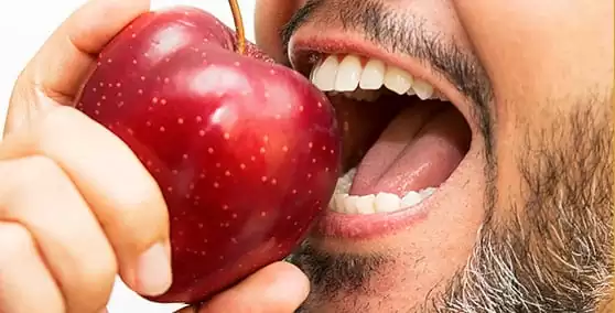 man eating an apple from hamilton dentist
