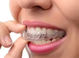 woman holding invisalign in gum graft surgery