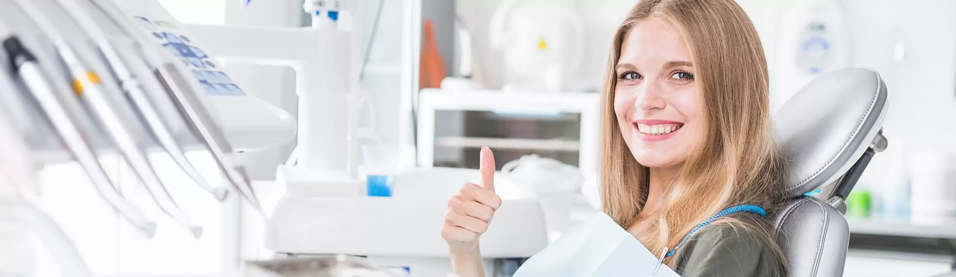 Smiling woman in dental chair giving thumbs up at hamilton cosmetic dentistry