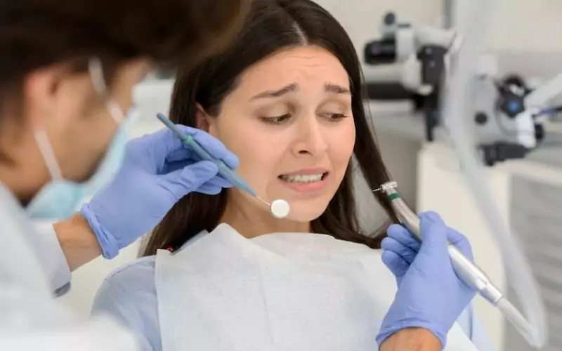 Uncertain patient with dental anxiety staring at dental tools in hamilton