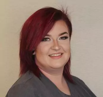 A woman with red hair posing for a photo.