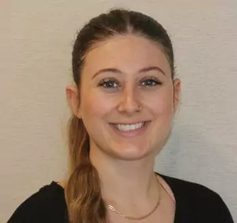 A woman wearing a black shirt and a necklace.