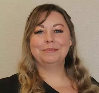 A woman in a black shirt is smiling for the camera.