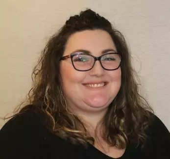 A woman wearing glasses and a black shirt.