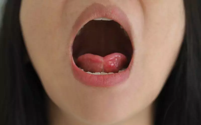 A close up of a woman's mouth with tongue out.
